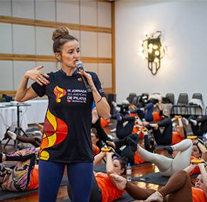 Instrutora conduzindo aula prática de Pilates