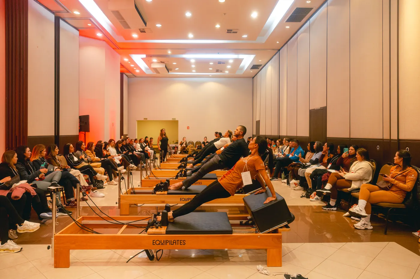 Workshop prático em Reformers com plateia ao redor